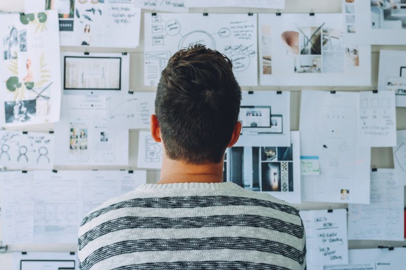 greenloopsolutions - Picture of a man facing a wall full of ideas