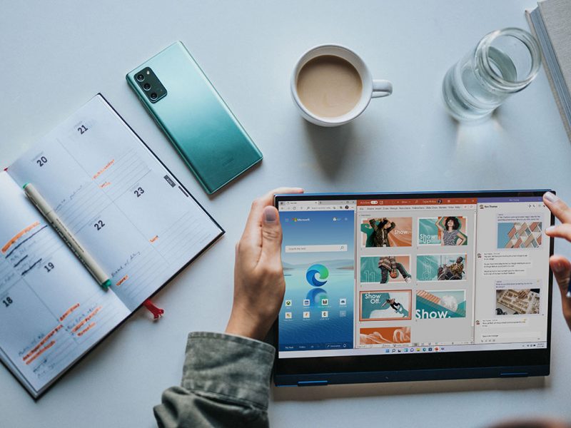 person holding a laptop that is powered by windows 11